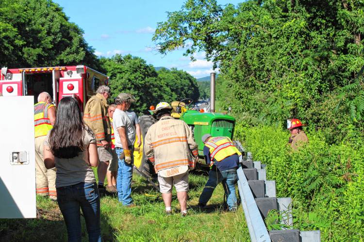 Northfield firefighters work to release a tractor from the guard rail on Route 10 in Northfield after a Ford Explorer rear-ended the tractor on Monday afternoon.