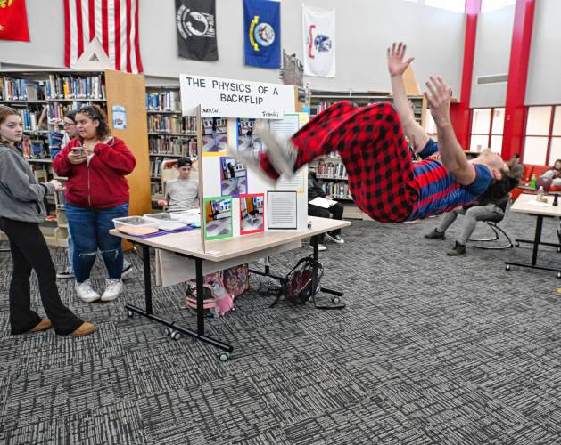 Ralph C. Mahar Regional School student Tristan Gaj demonstrates a backflip at the school science fair last week, where he and Owen Carl explored the physics of the maneuver.