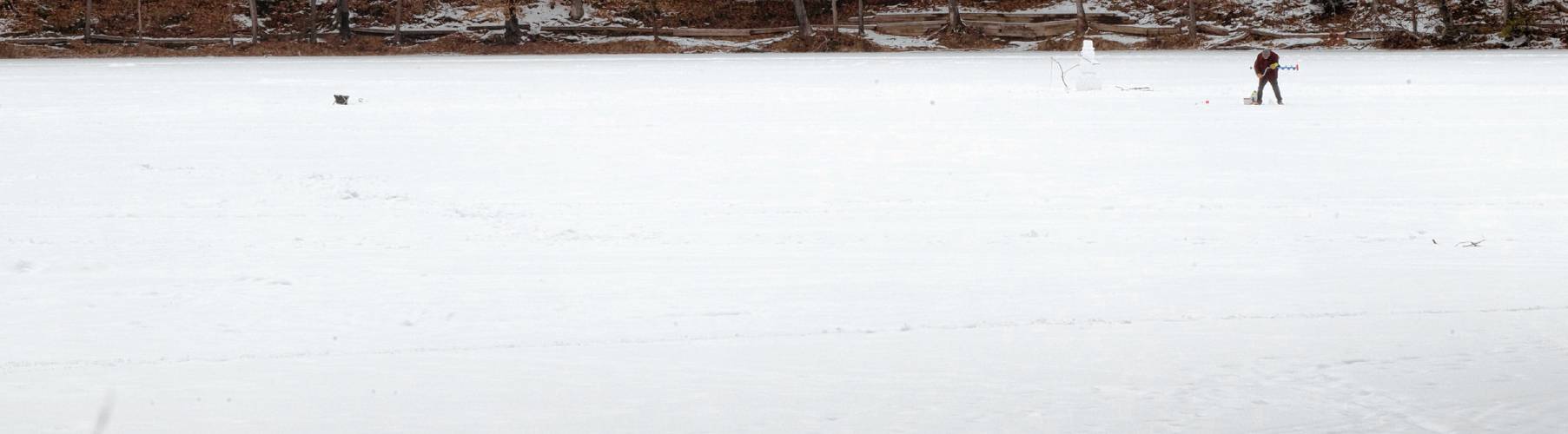 An ice fisherman on Puffer’s Pond in Amherst. Public safety officials warn residents to never trust ice over a body of moving water — one that has a flow or current.