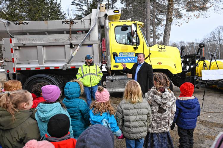 Matt Minihan, of the state Department of Transportation, and state Rep. Aaron Saunders talk with students about the snowplow named by Swift River School student Teddy Koonz.