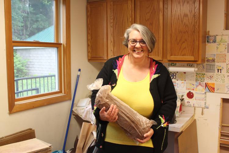Artspace Operations Manager Jillian Henry holds a bag of clay