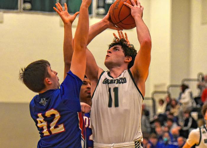 Greenfield’s Jon Breor (11) tries to put up a shot over Drury’s Colin Daly (42) during the Green Wave’s 41-38 Hampshire League South victory on Monday night at Nichols Gymnasium in Greenfield.
