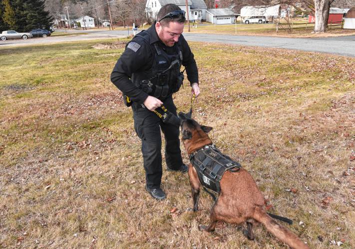 Orange Police Officer Christopher Bisceglia plays with retired K-9 Orka.