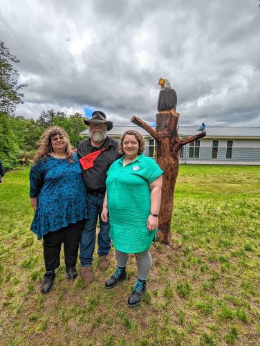 Artists John and Doris Lake and Library Director Abby Baines pose for a photo with a new natural materials sculpture at the Erving Public Library that was unveiled during Sculpture Fest on Sunday, May 19.