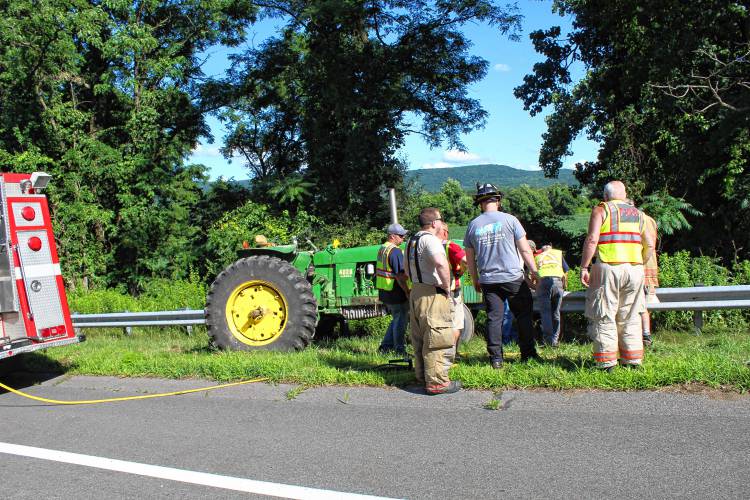 Northfield firefighters work to release a tractor from the guard rail on Route 10 in Northfield after a Ford Explorer rear-ended the tractor on Monday afternoon.