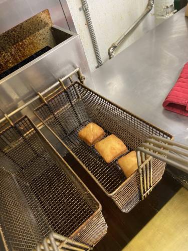 Once the beignets are cooked, remove them from the oil. Let them rest; then drain them. Wesley has a fryer so she just lifts the basket out and lets it drain into the oil, but you may need to blot your beignets on paper towels.