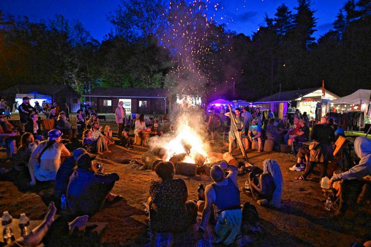Festival goers around the fire pit on Saturday night at the 20th StrangeCreek Campout at Camp Kee-wanee in Greenfield.