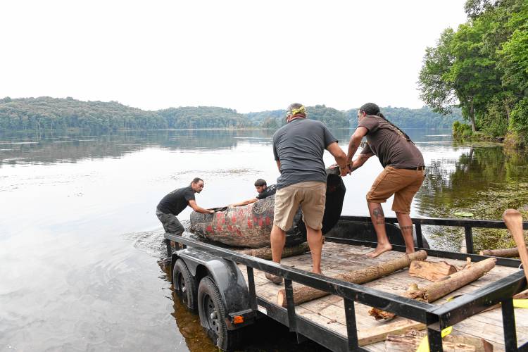 A mishoon, a Native American dugout canoe, is launched into Barton Cove on Friday.