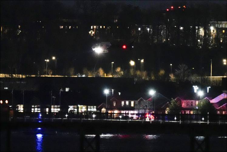 A helicopter uses its searchlight as it flies above the Potomac River near Ronald Reagan Washington National Airport Wednesday, Jan. 29, 2025, in Arlington, Va. (AP Photo/Alex Brandon)