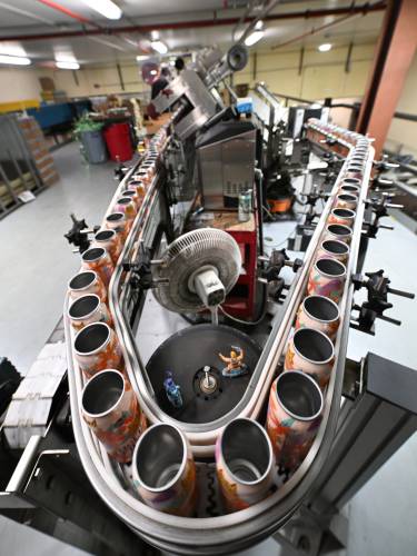 Aluminum cans receive labels before being filled and sealed at Berkshire Brewing Co. in South Deerfield. Local businesses are bracing for the impact that steel and aluminum tariffs could have on their bottom line.