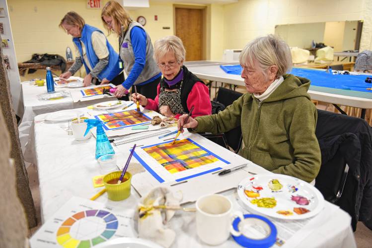 Greenfield resident Sandy Kosterman, center, and Erving resident Sue Sharbaugh, right, learn how to blend colors using acrylic paints before tackling subjects in an art class at the Bernardston Senior Center taught by Dianne  Cornwell on Tuesday. 