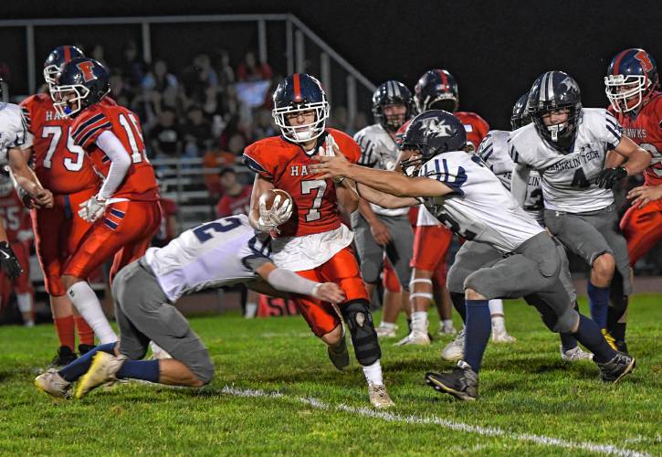 Frontier’s Garrett Dredge is tackled by a pair of Franklin Tech defenders in South Deerfield Friday night. 