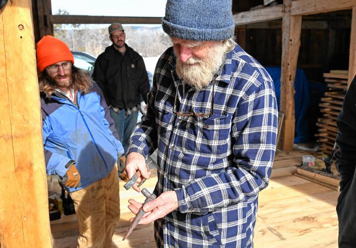 Ashfield blacksmith Ned James with hinges he is replicating for the doors in the rebuilt barn at the Wilder Homestead in Buckland.
