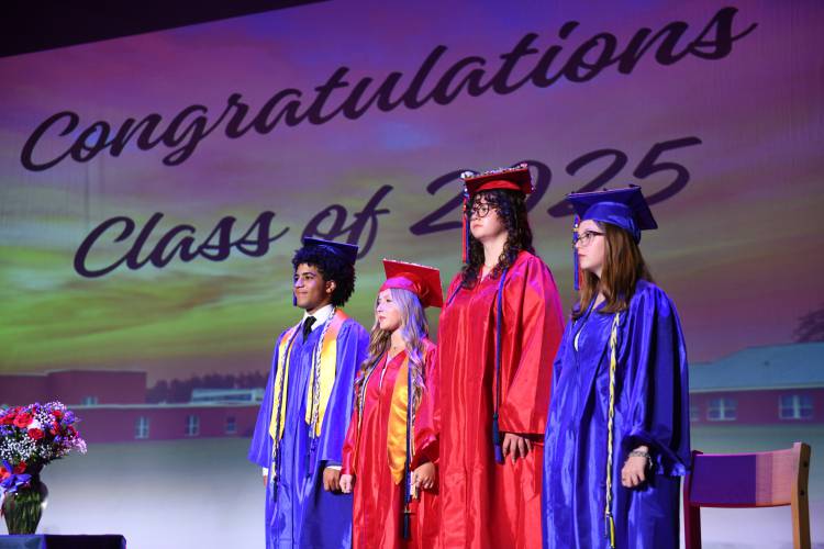 Luan Lopez Baez, Shea Woods, Delana Fausett and Kayla Quinn stand on stage at the beginning of commencement exercises at Ralph C. Mahar Regional School Friday evening.