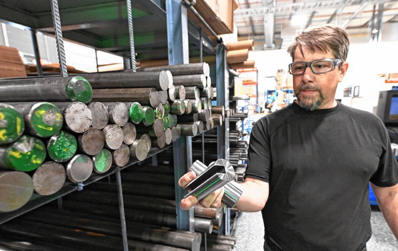 Jason Bradley, of Pilot Precision Products in South Deerfield, with raw steel stock and a finished product. Local businesses are bracing for the impact that steel and aluminum tariffs could have on their bottom line.