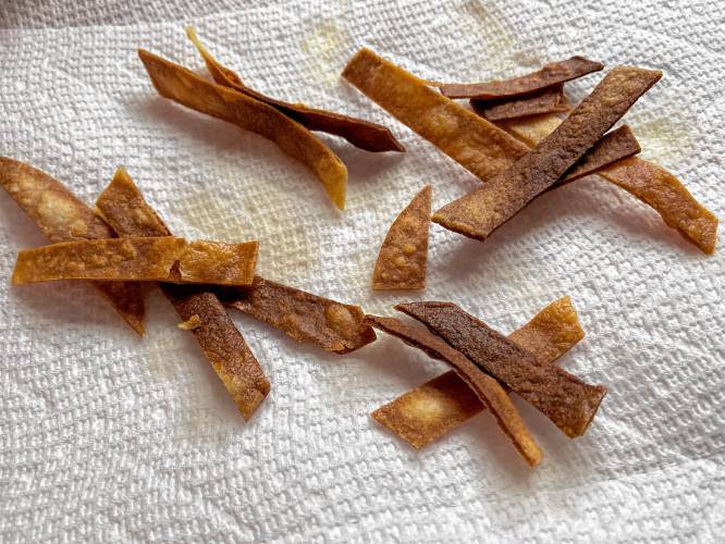 Tortilla crisps are so easy to make — they are just corn tortillas cut into small strips and fried briefly in canola oil and then drained on paper towels.