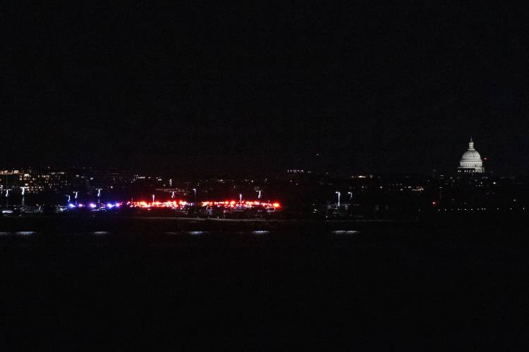 Emergency vehicles stage at Ronald Reagan Washington National Airport Wednesday, Jan. 29, 2025, in Arlington, Va. The U.S. Capitol is seen, right, across the Potomac River in Washington. (AP Photo/Kevin Wolf)