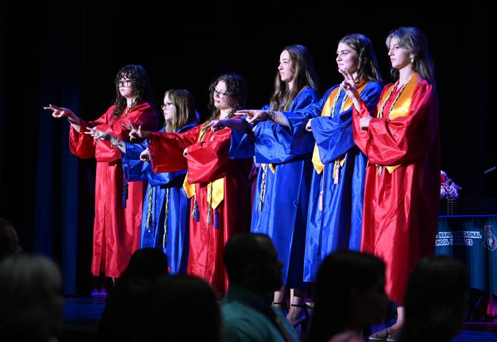 Seniors sign the Star-Spangled Banner using American Sign Language at the beginning of commencement exercises at Ralph C. Mahar Regional School Friday evening.
