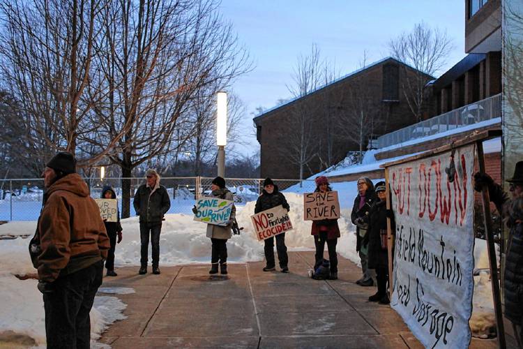 Activists with signs and banners were advocating against the state Department of Environmental Protection’s draft water quality certification for FirstLight Hydro Generating Co. before a hearing at the Cohn Family Dining Commons at Greenfield Community College Wednesday night.