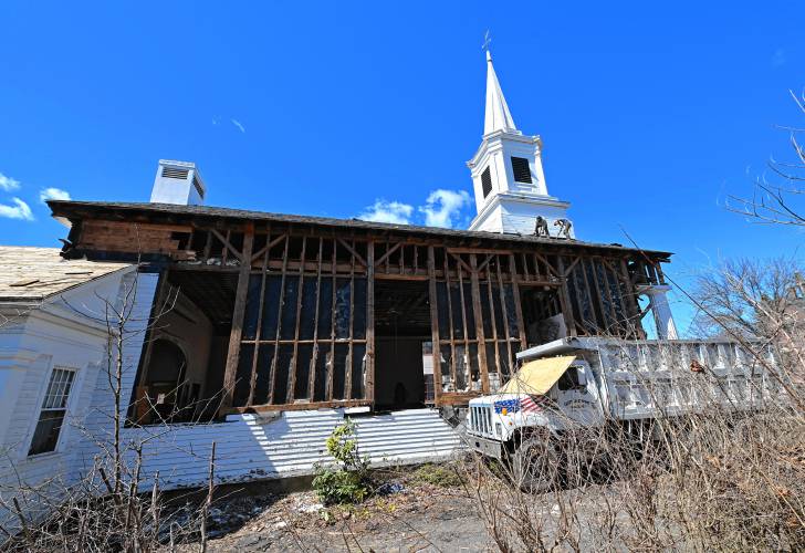 Workers from Carter & Stevens Farm LLC in Barre begin to remove the roof from the former Zion Korean Church on Main Street in Greenfield on Thursday.