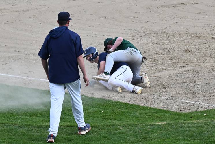 Frontier’s Collin West slides through Greenfield third baseman Chase Zraunig for a triple at Veterans Field in Greenfield on Thursday. 