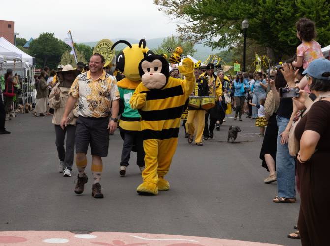 Kim Clark leads the Expandable Brass Band and community members in a parade at Saturday’s Bee Fest.