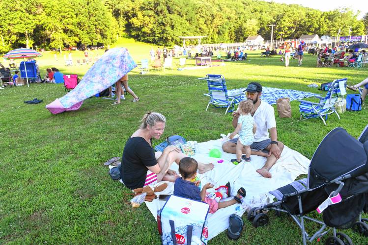 Kelly White, formerly of Greenfield, now from Texas, is back visiting with her husband Lee Terrazas and children Thiago, 2, and Luca, 1, waiting for the fireworks at the Independence Day celebration at Beacon Field on Sunday.