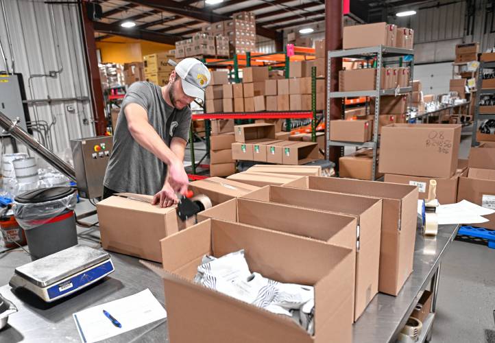 Nikko Sciandra boxes up bags of coffee at Fogbuster Coffee Works in Greenfield.