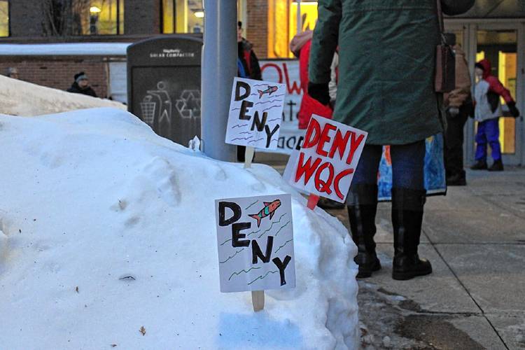 Signs reading “Deny” were planted in the snowbanks outside the entrance of the main building at Greenfield Community College on Wednesday ahead of a public hearing on the state Department of Environmental Protection’s draft water quality certification for FirstLight Hydro Generating Co. 