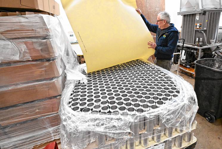 Dan Kramer, of Element Brewing Co. in Millers Falls, uncovers stacks of aluminum cans, known in the industry as brites.
